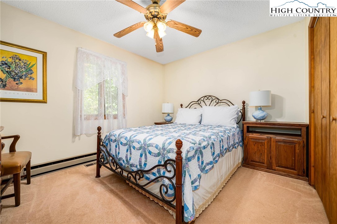 424 Poga Road Butler, TN 37640 - Photo 25 of 40 a bedroom with a bed and a chandelier