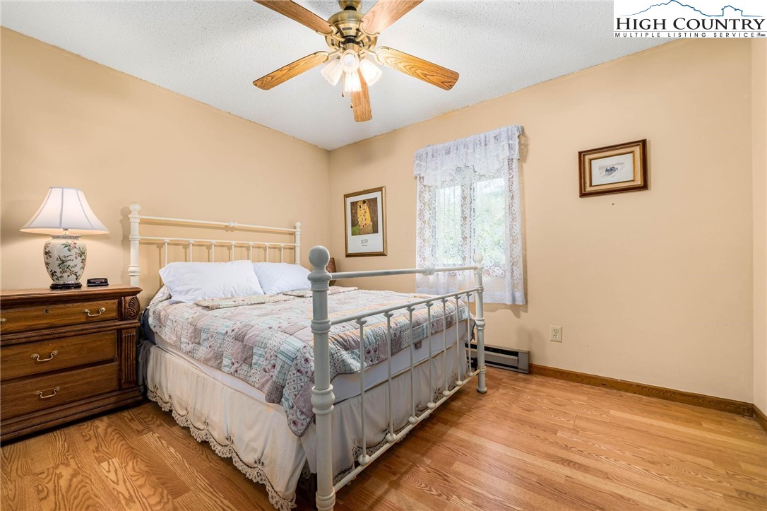 424 Poga Road Butler, TN 37640 - Photo 27 of 40 a bed room with a bed and a chandelier