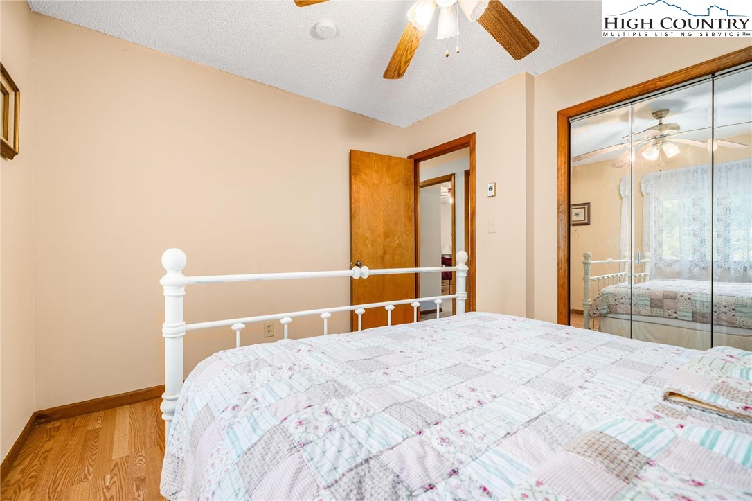 424 Poga Road Butler, TN 37640 - Photo 28 of 40 a bedroom with a large bed and a chandelier
