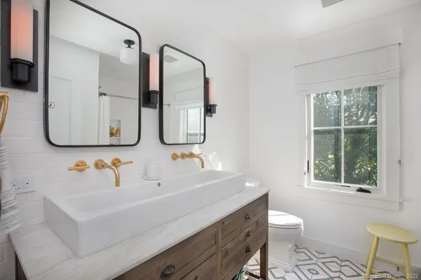 a bathroom with a sink and a mirror with toilet