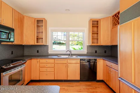 a kitchen with stainless steel appliances granite countertop a stove a sink and a microwave