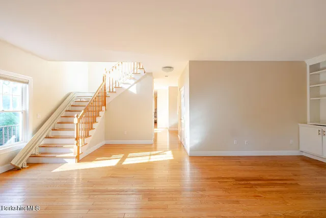 a view of a room with wooden floor and white walls