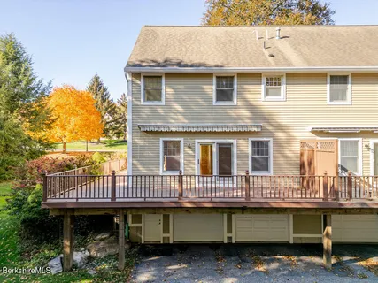 a view of a house with wooden deck and furniture