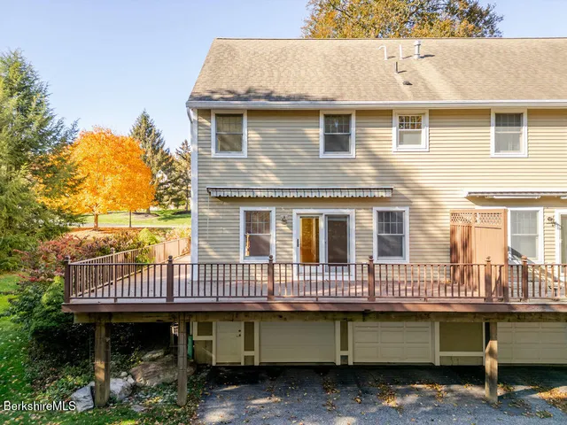 a view of a house with wooden deck and furniture