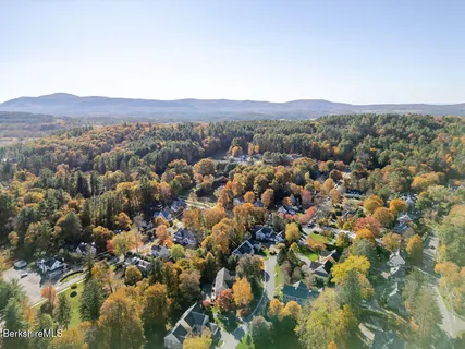 a aerial view of a house with a yard and large trees