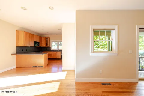 a view of kitchen and hall with wooden floor