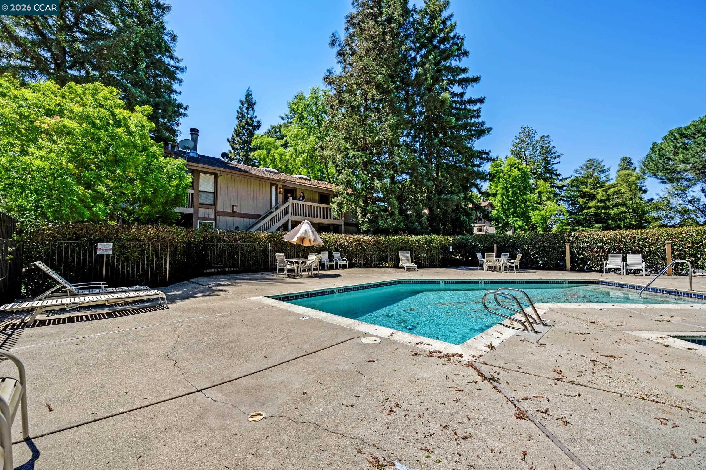 1544 Bailey Road, Unit 30 Concord, CA 94521 - Photo 30 of 33 a view of a backyard with table and chairs a fire pit and large trees