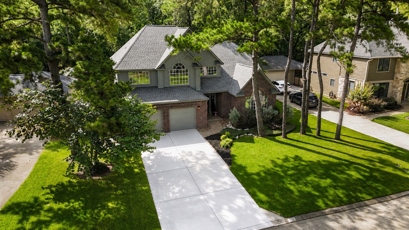 102 Treescape Circle Spring, TX 77381 - Photo 30 of 40 This home showcases a charming two-story exterior with a modern design, nestled among tall trees. It features a well-maintained lawn, a spacious driveway, and a welcoming entrance.