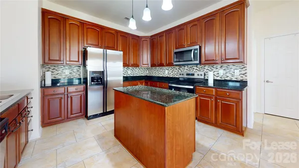 a kitchen with stainless steel appliances granite countertop a stove refrigerator sink and microwave