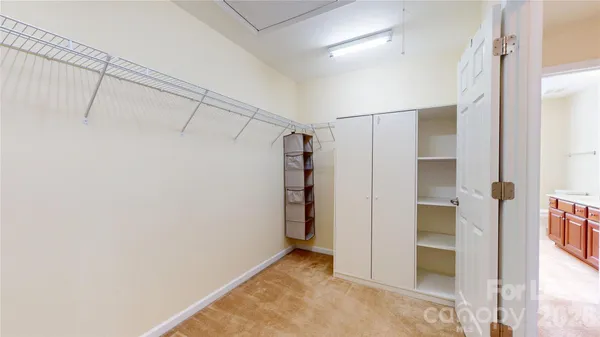 a view of walk in closet with empty racks