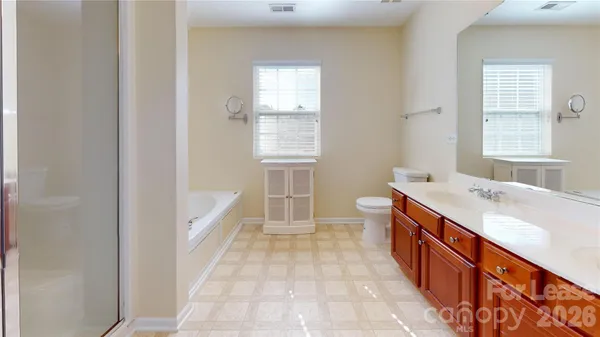 a large bathroom with a tub sink and mirror