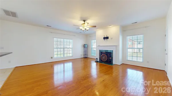 a view of an empty room with a fireplace and a window