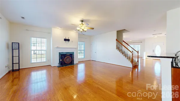 a view of a livingroom with wooden floor fireplace and a window