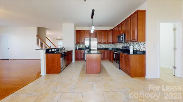 a kitchen with stainless steel appliances granite countertop a stove top oven a sink dishwasher and cabinets