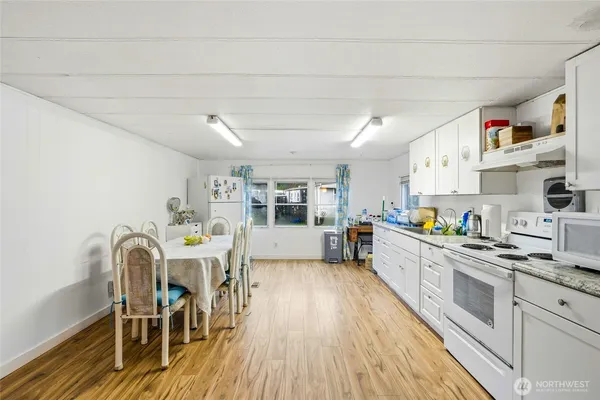 a kitchen with stainless steel appliances a white wooden cabinets and stove top oven