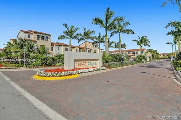 a view of a swimming pool with a yard and palm trees