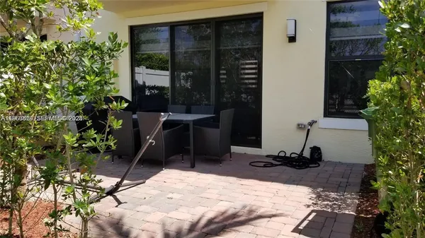 a view of a backyard with chair and potted plants