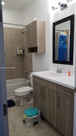a bathroom with a toilet a sink and mirror
