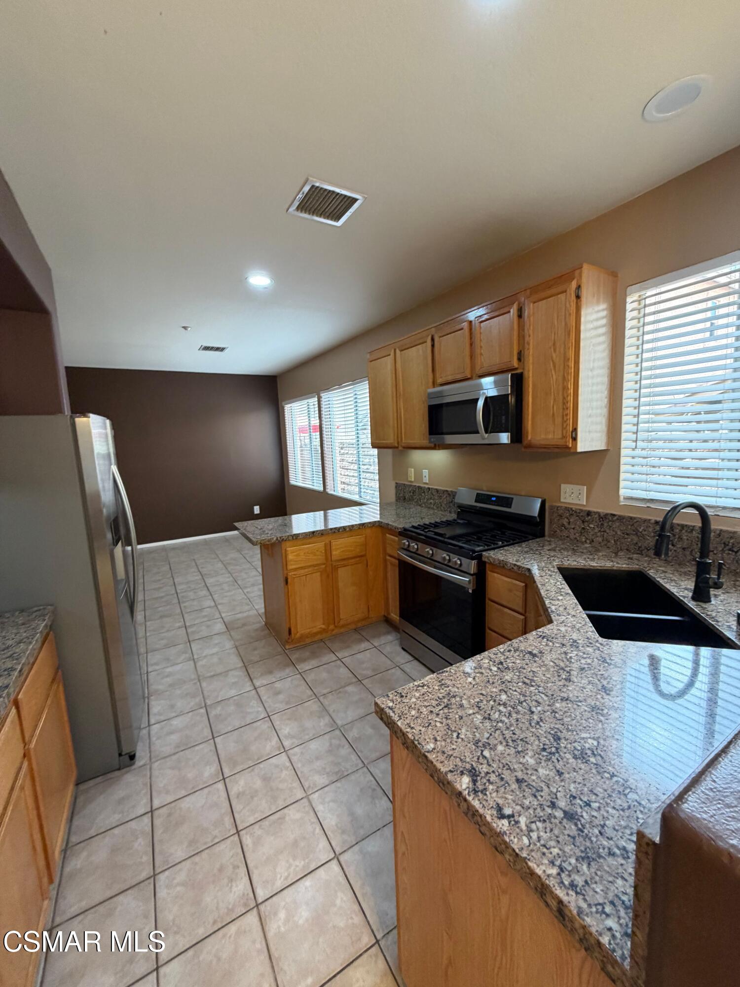 1961 Brookberry Lane Simi Valley, CA 93065 - Photo 3 of 23 a kitchen with stainless steel appliances granite countertop a sink stove and refrigerator