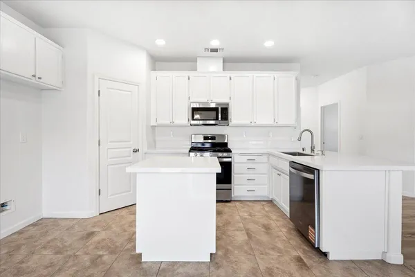 a kitchen with cabinets stainless steel appliances and a counter space
