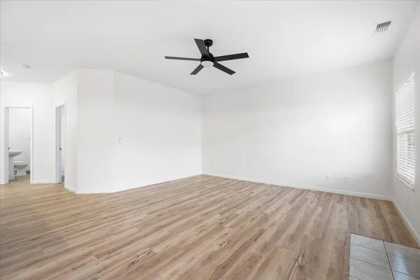 a view of empty room with wooden floor