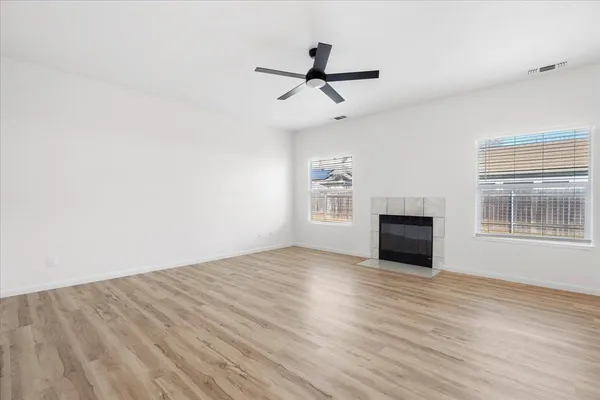 a view of empty room with wooden floor and window