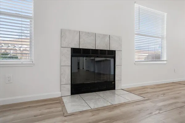 an empty room with wooden floor and window