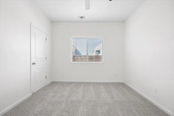 an empty room with a white cabinet and a window