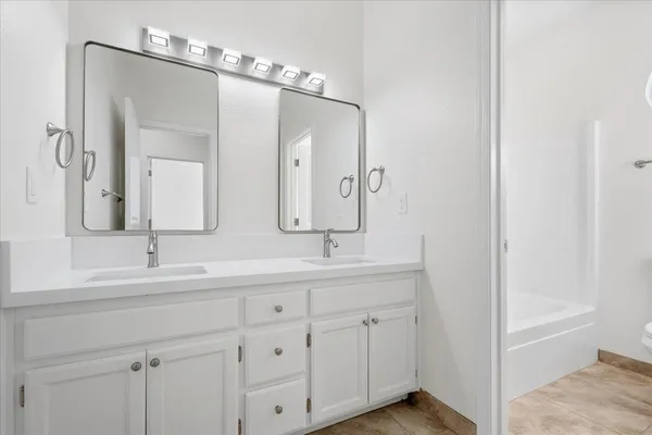 a bathroom with a double vanity sink mirror and