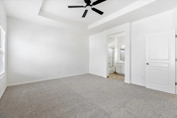 an empty room with closet and a ceiling fan