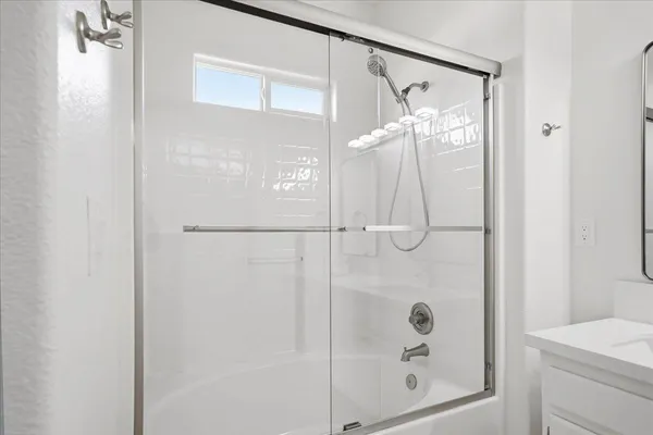 a bathroom with a glass shower door and a mirror