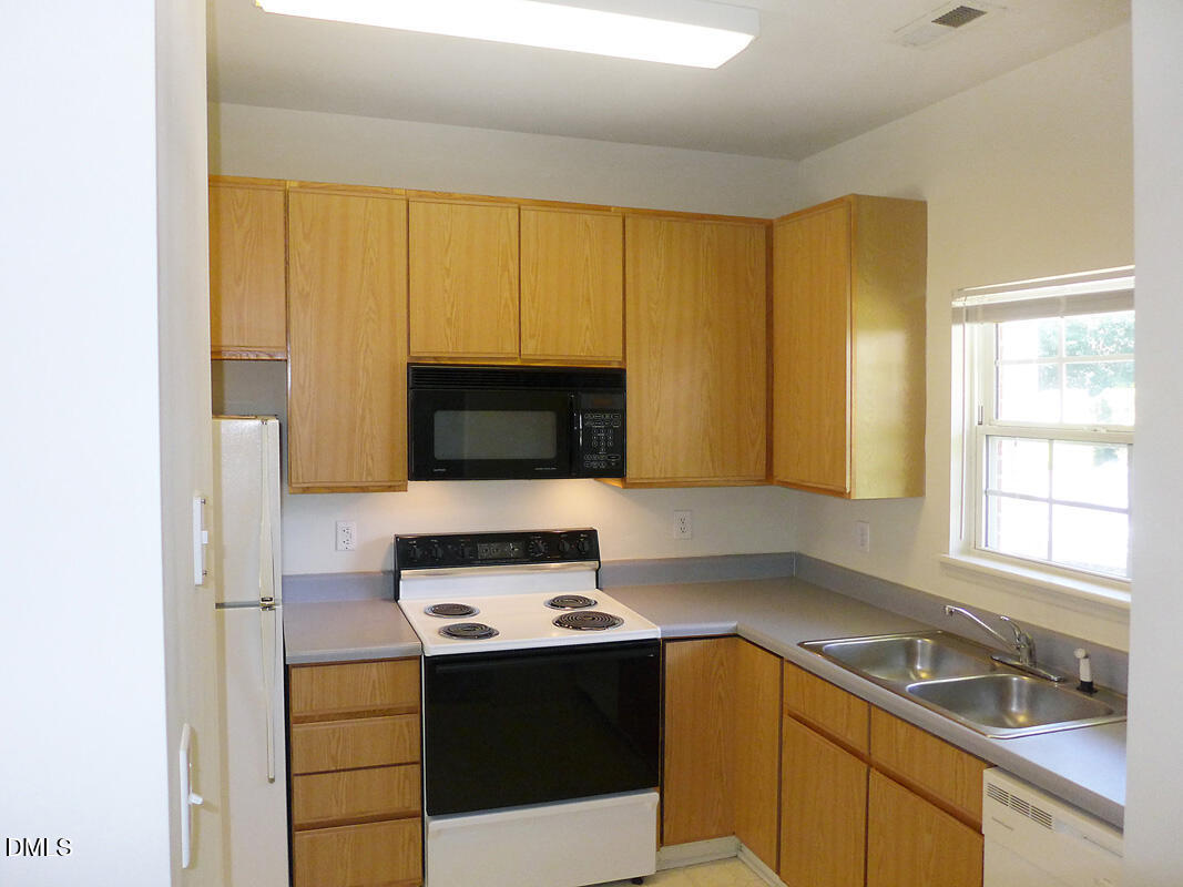 101 Rock Haven Road, Unit C301 Carrboro, NC 27510 - Photo 4 of 12 a kitchen with a sink stove and microwave