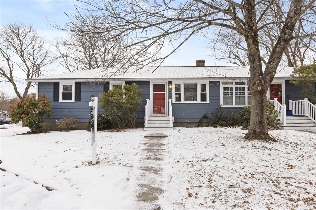 a front view of a house with a yard covered in snow