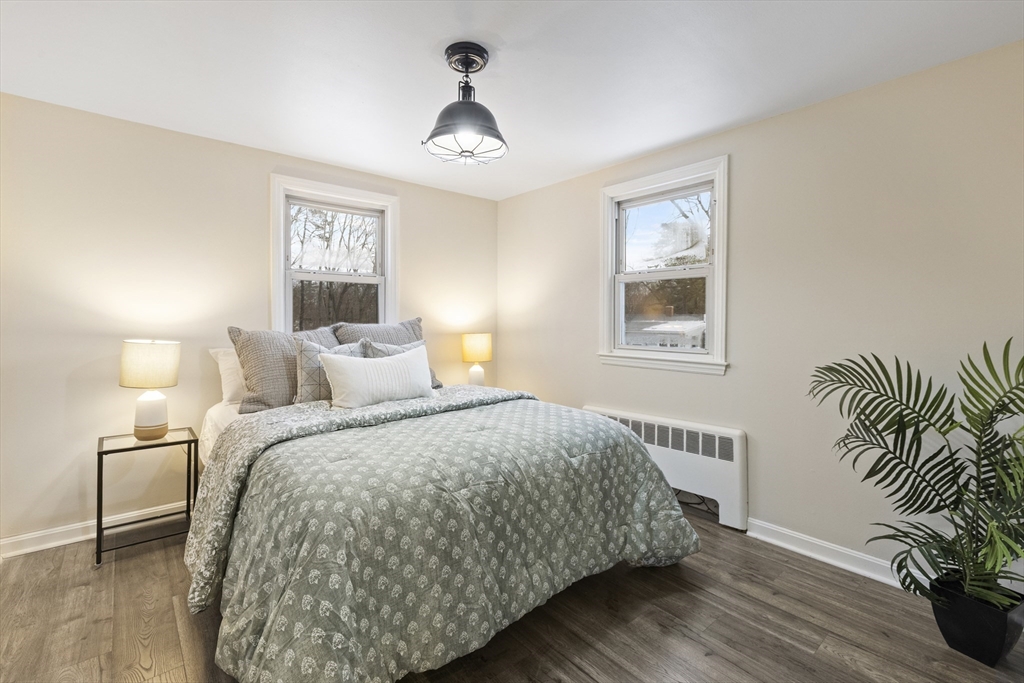 58 Neillian Way, Unit 58 Bedford, MA 01730 - Photo 7 of 23 a bed sitting in a bedroom next to a lamp