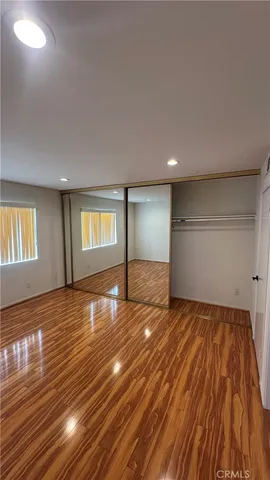 a view of empty room with wooden floor and window
