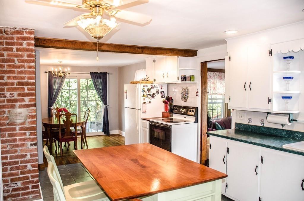 183 Lancaster Road Berlin, MA 01503 - Photo 5 of 41 a kitchen with stainless steel appliances kitchen island granite countertop a table chairs in it and wooden floors