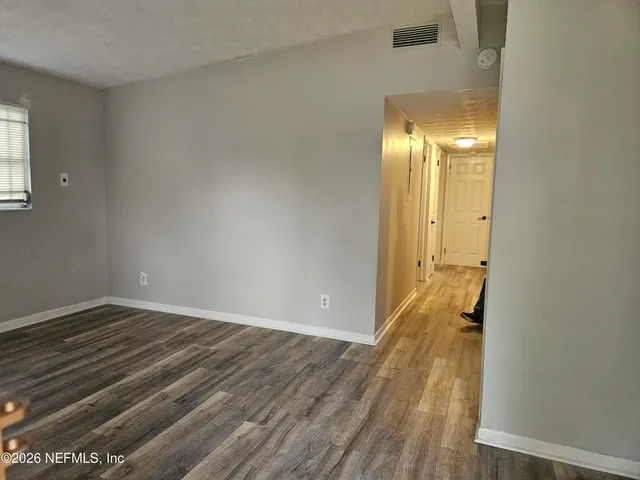 an empty room with wooden floor and a window