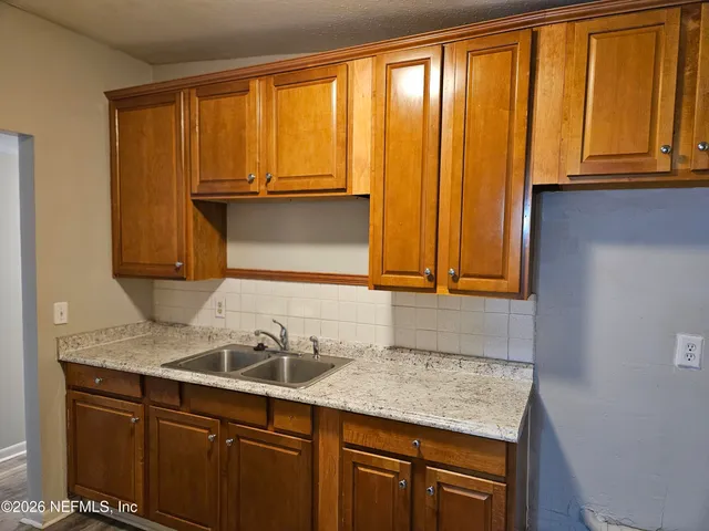 a bathroom with a granite countertop sink and a mirror next to a window