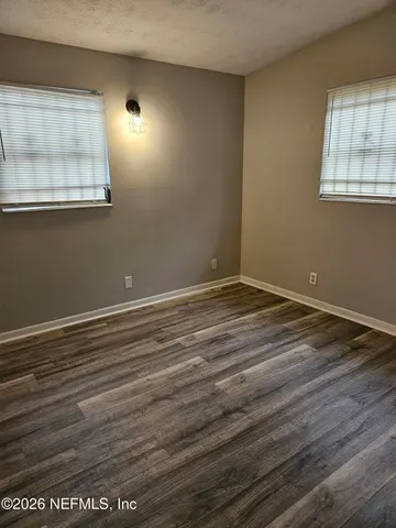 a view of room with window and wooden floor