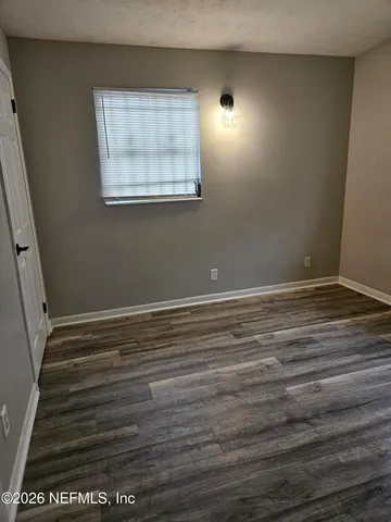 a view of room with window and wooden floor