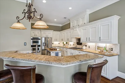 a kitchen with granite countertop a sink a center island and stainless steel appliances