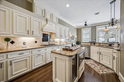 a kitchen with granite countertop a sink stove and cabinets