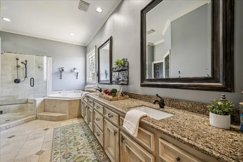a bathroom with a granite countertop tub sink and mirror
