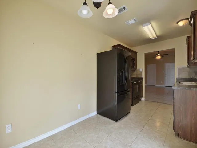 a view of a refrigerator in kitchen and a window