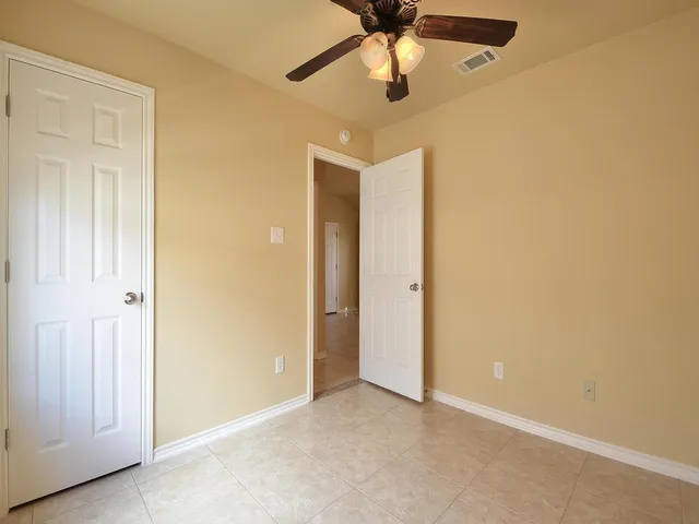 an empty room with a ceiling fan and a fan