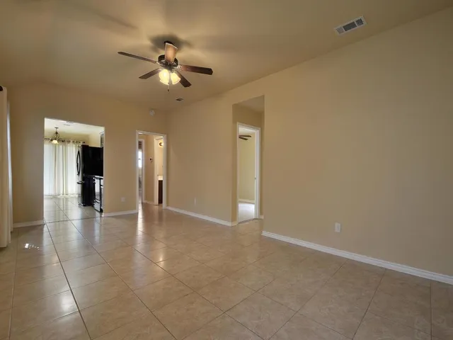 a view of an empty room and kitchen view