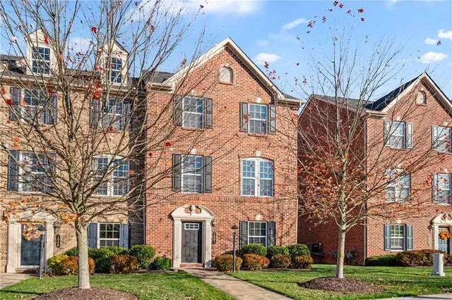 a front view of residential houses with yard and green space