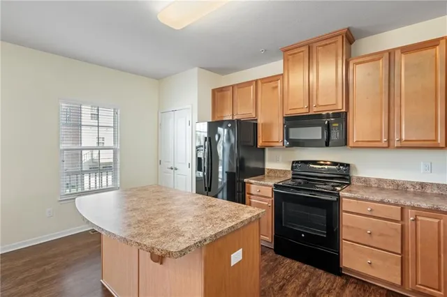 a kitchen with granite countertop a stove sink and refrigerator