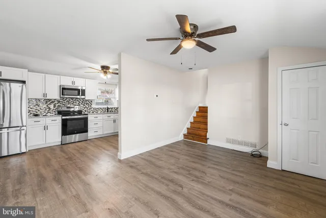 a view of a kitchen with a ceiling fan and wooden floor