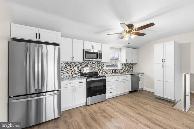 a kitchen with stainless steel appliances a refrigerator sink and microwave